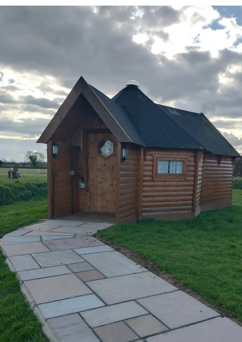 A paved path leading to a yurt’s covered porch