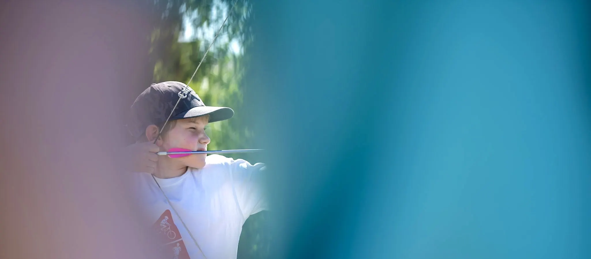 A young archer at full draw on the archery field