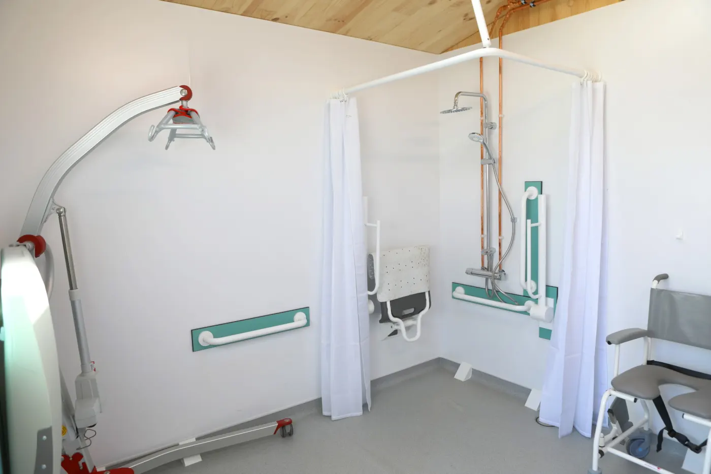 The second accessible shower room, with a mobile hoist, a curtained level-access shower, fold-down seat and shower chair