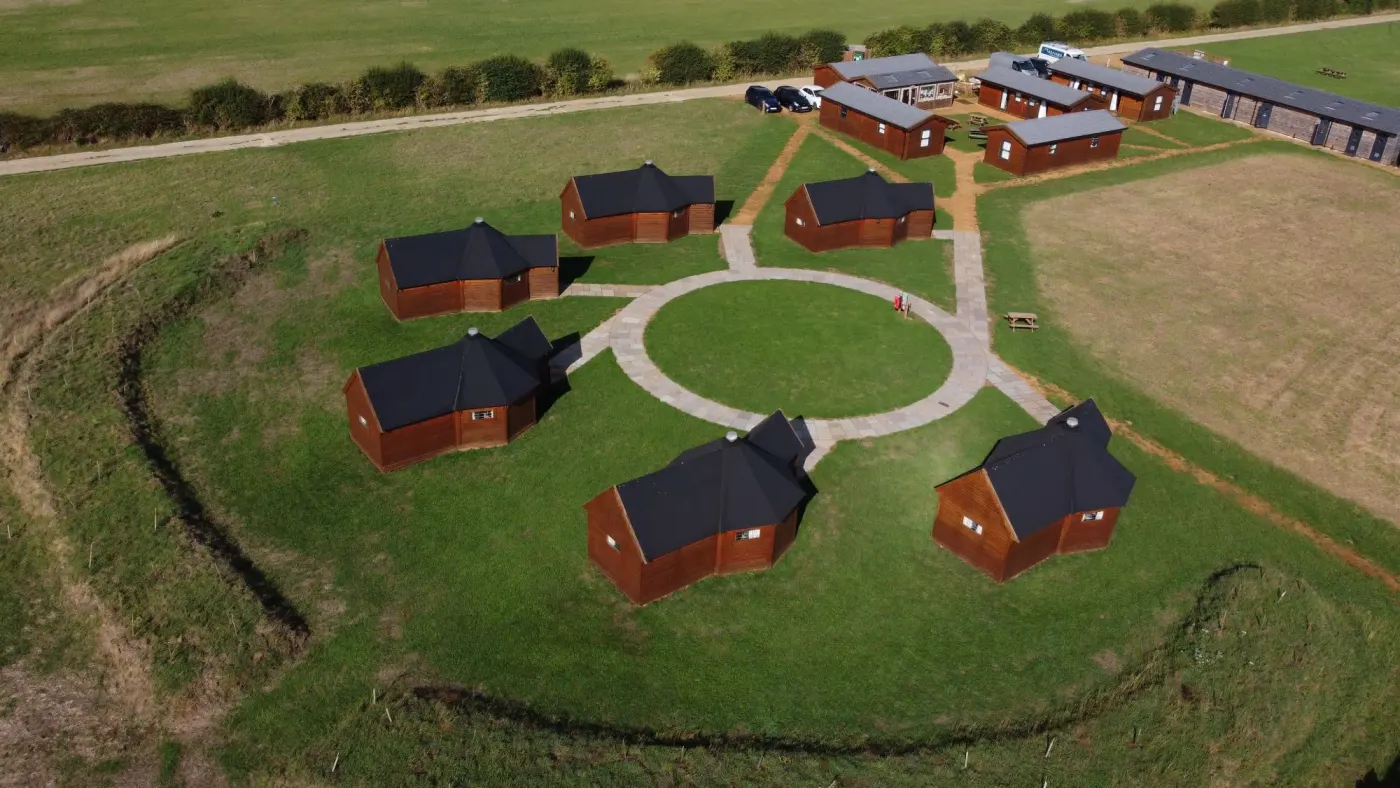 The yurt village from above: yurts around a paved circle, with the cabins and shower block beyond