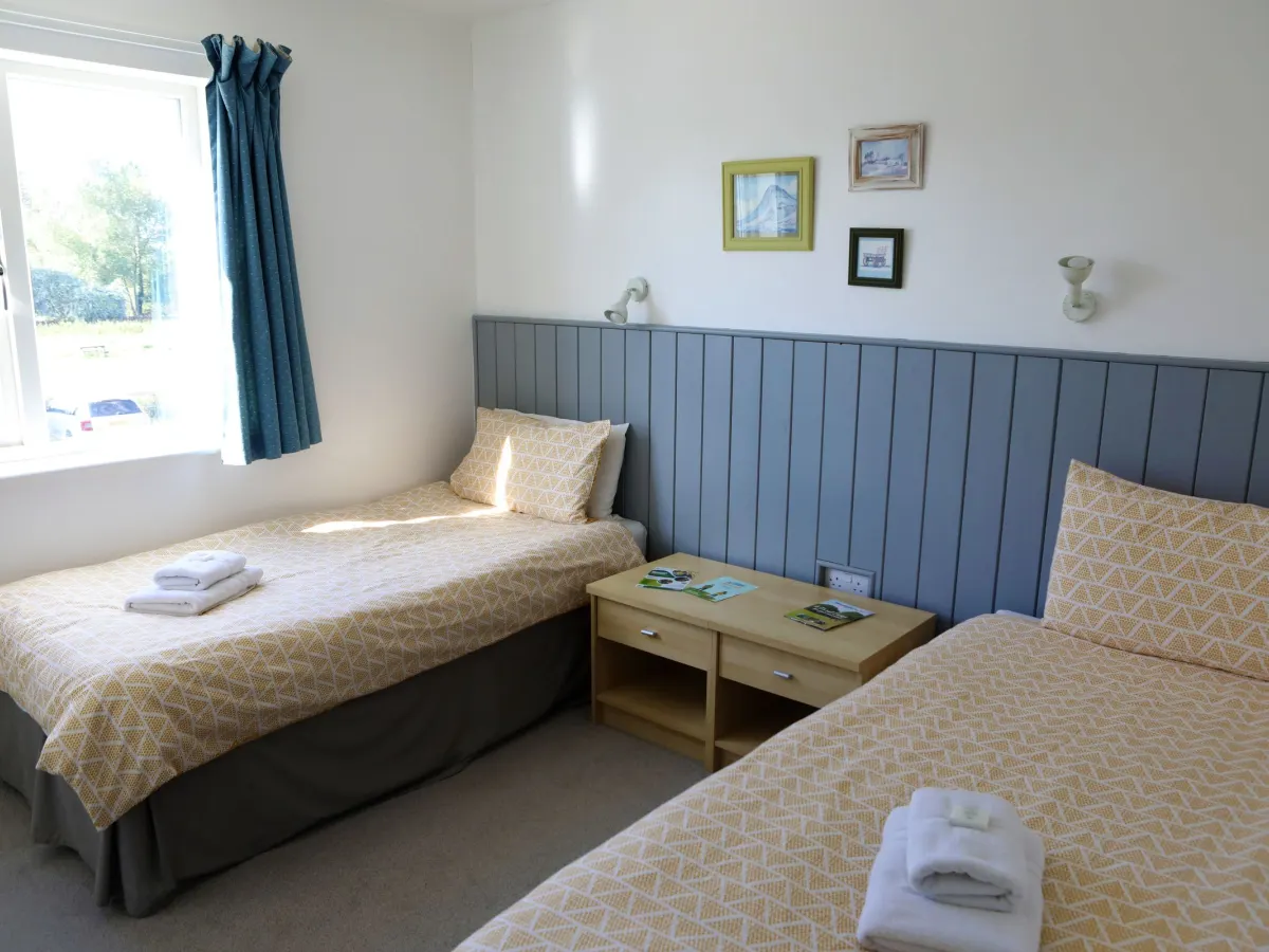 A twin room in Wellspring with fresh towels on the beds